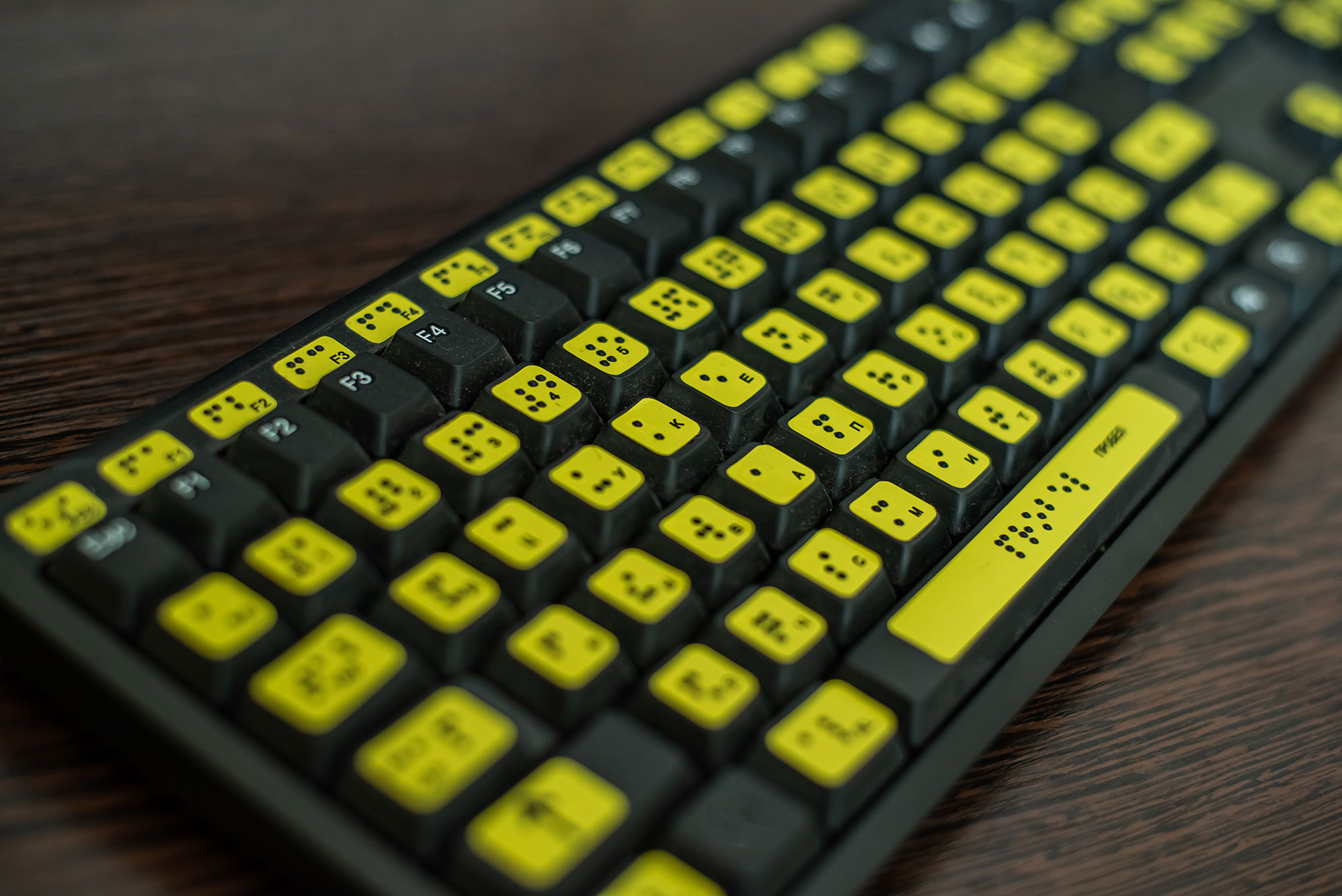 Schwarze Tastatur mit gelben Tastenmarkierungen und Brailleschrift.